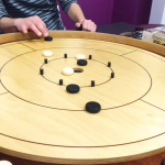 Crokinole board with wooden discs showing concentric scoring rings