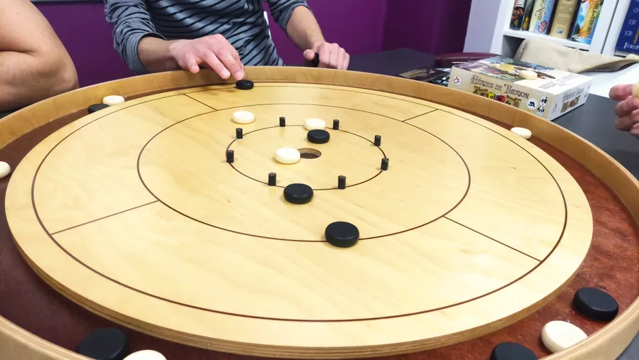 Crokinole board with wooden discs showing concentric scoring rings