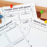 Colorful handmade board game prototype with cards, dice, and game pieces on wooden table